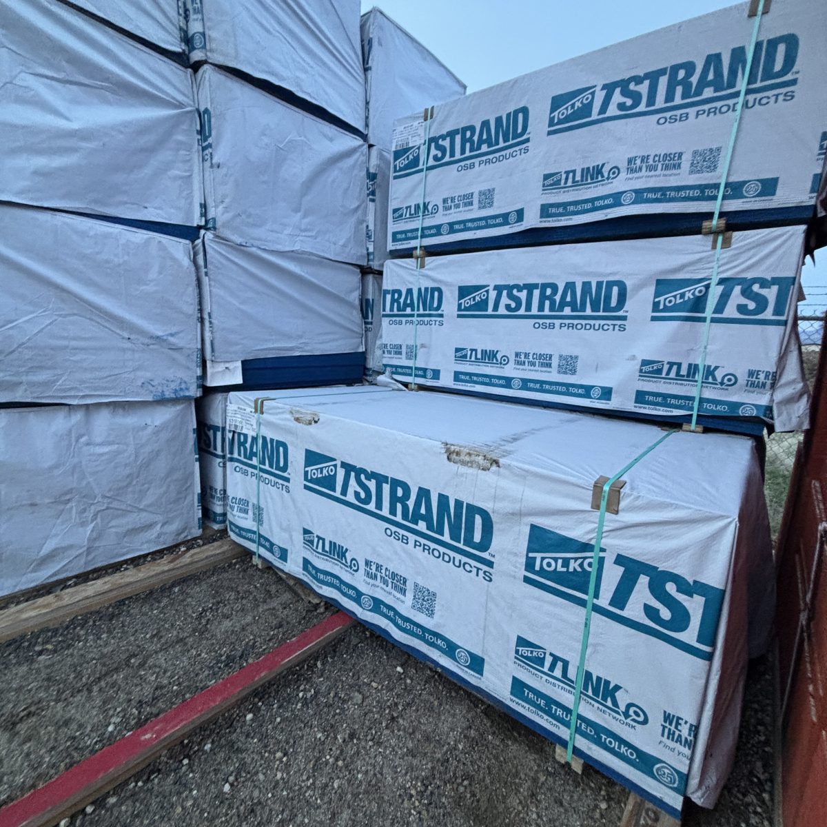 Angled view of 19/32 inch 4x8 OSB sheathing stacked at Boise lumberyard with other lumber SKUs visible