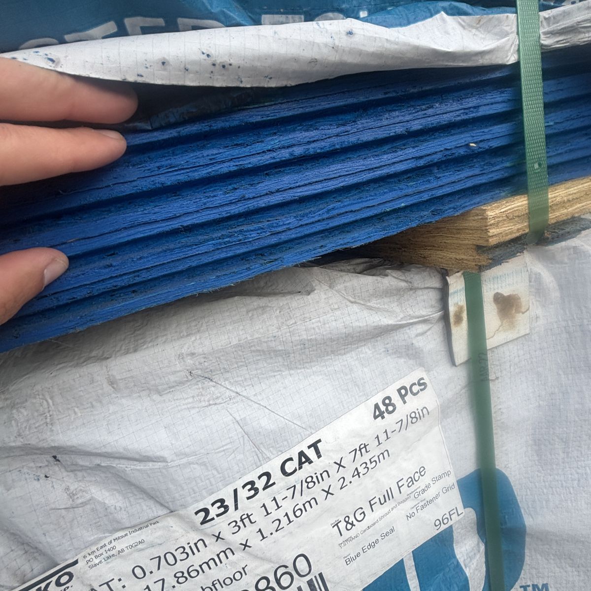 Close view of Tolko 23/32 inch tongue-and-groove OSB subfloor sheathing showing interlocking edge profile