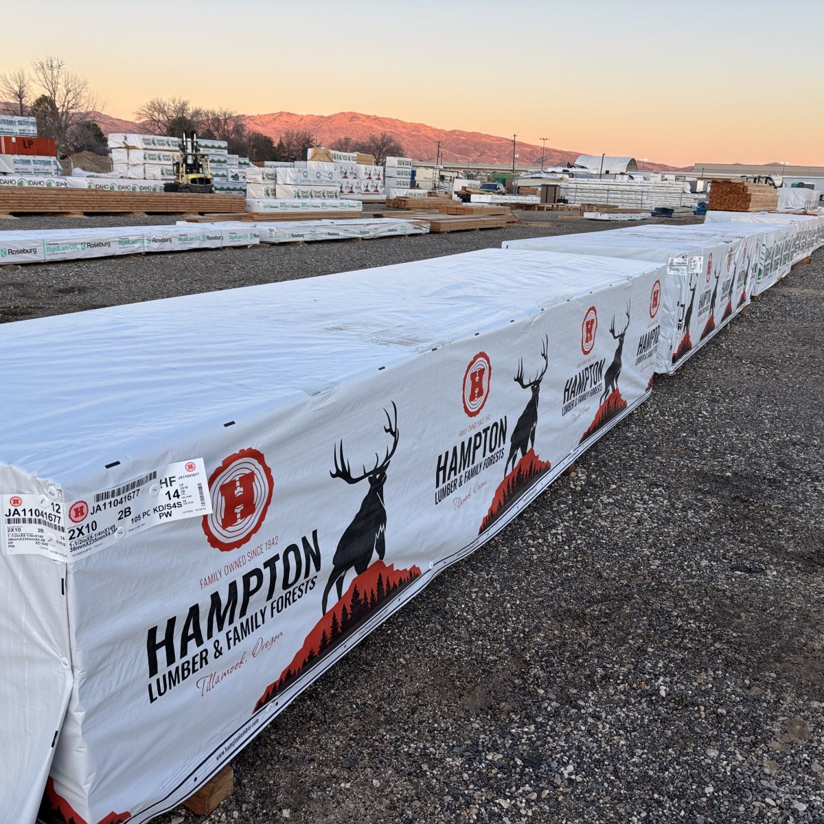 Angled view of multiple units of 2x10x14 foot number 2 grade kiln-dried Hem-Fir lumber stacked at Boise lumberyard